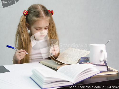 Image of Girl leafing through book and wrote on a sheet of paper abstract sitting