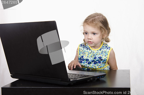 Image of girl working at a laptop and looked mysteriously in frame