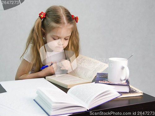 Image of Girl leafing through book and wrote on a sheet of paper abstract sitting