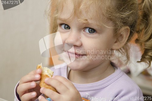 Image of little girl with enthusiasm and eats roll pleasure