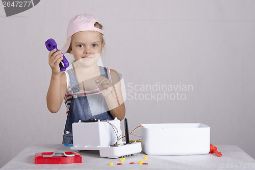 Image of Girl repairs toy small home appliances