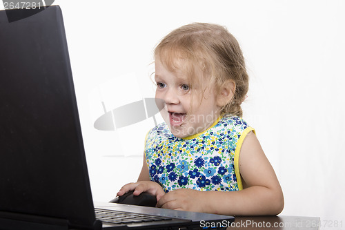 Image of girl working at a laptop and looked mysteriously in frame