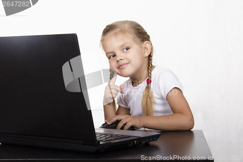 Image of girl sitting in table, working at laptop