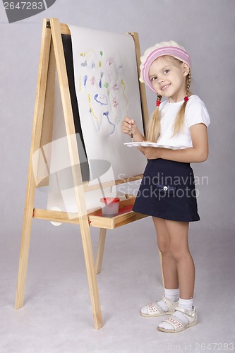 Image of The girl in image of artist draws on easel