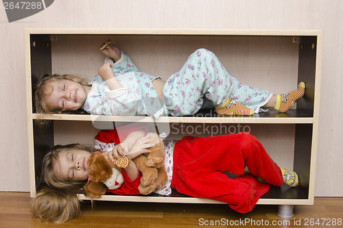 Image of Two of children to lie on shelves, bedside tables