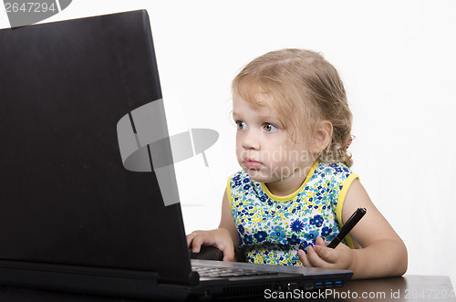 Image of girl working at a laptop and looked mysteriously in frame