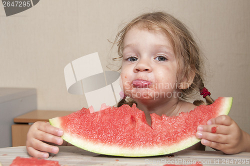 Image of Two-year-old girl eating watermelon with cheerful faces