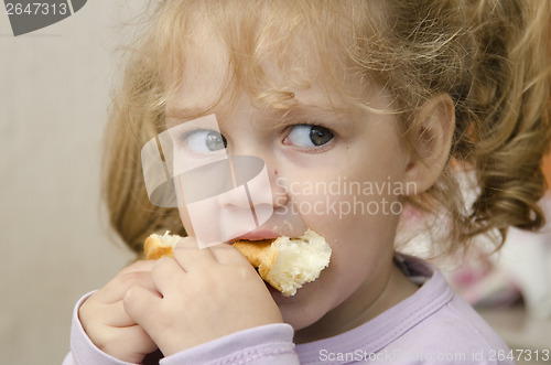 Image of little girl with enthusiasm and eats roll pleasure
