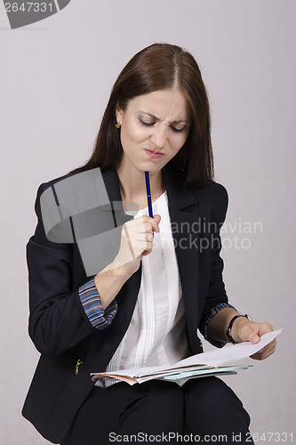 Image of School teacher checks notebooks students with homework