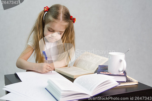 Image of Girl leafing through book and wrote on a sheet of paper abstract sitting