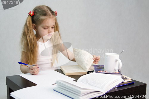 Image of Girl leafing through book and wrote on a sheet of paper abstract sitting