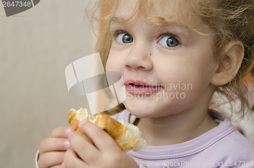 Image of little girl with enthusiasm and eats roll pleasure