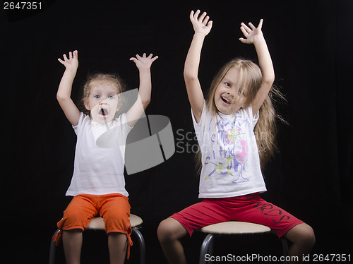 Image of Two little girls raised their pens