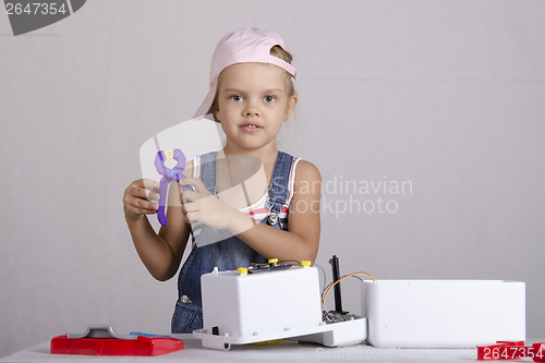 Image of Girl repairs toy small home appliances