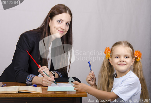 Image of teacher teaches lessons with student sitting at table