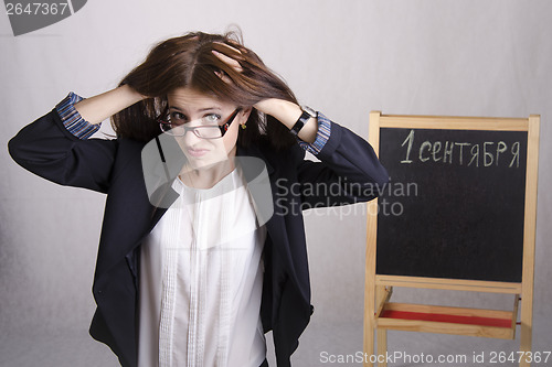 Image of school teacher with a scowl, holding his head