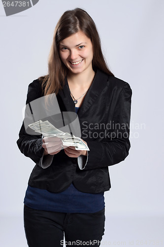 Image of Young long-haired woman holding money