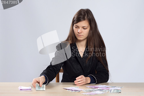 Image of Young woman counts money