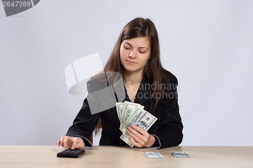 Image of Young woman counts money