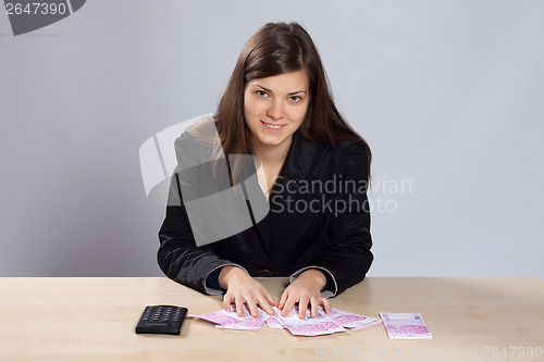 Image of Young woman counts money