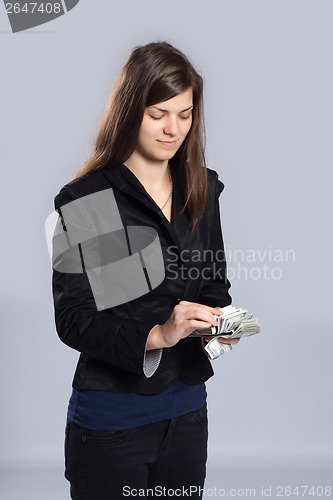 Image of Young woman counts money