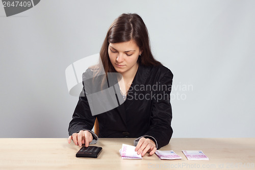 Image of Young woman counts money