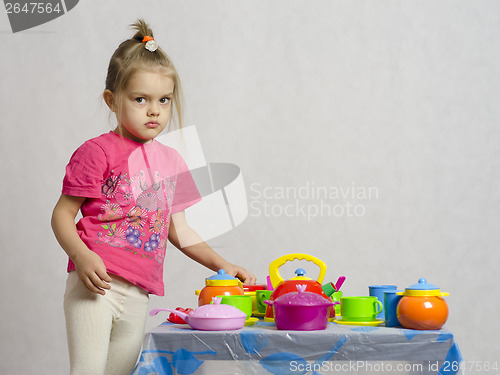 Image of Girl plays child kitchen utensils
