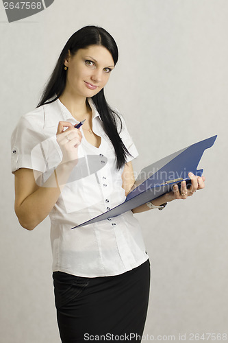 Image of Business girl listens and makes notes in a folder