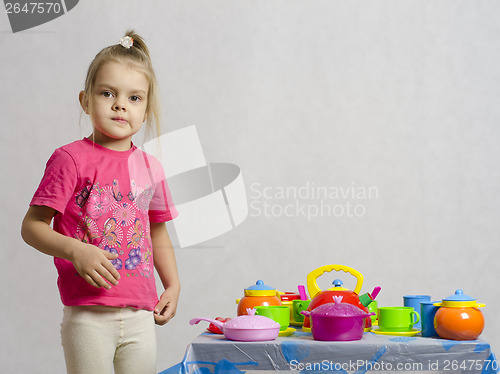 Image of Girl plays child kitchen utensils