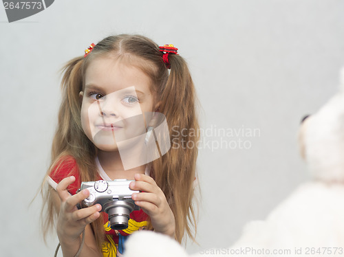 Image of Girl takes photo of Teddy digital camera