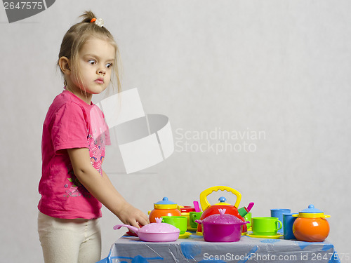 Image of Girl plays child kitchen utensils