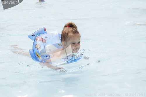 Image of Four-year-old girl swimming in pool on a circle