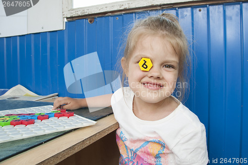 Image of Girl stuck in eye mosaic with letter and smiles