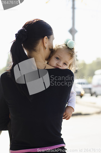 Image of Mother is in hands of child a crowded place