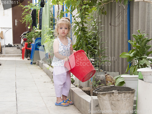 Image of girl standing in the garden with a red bucke