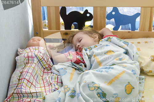 Image of Girl sleeping in the crib with a doll