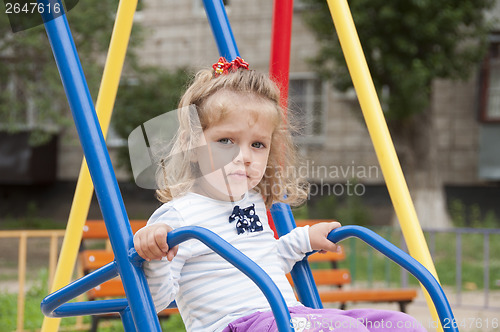 Image of Girl riding on a swing in the Playground