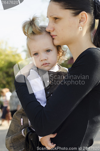 Image of Mother is in hands of a child crowded place