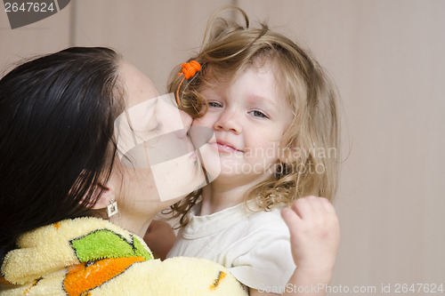 Image of Mom hugs and kisses awakened fuzzy-looking child