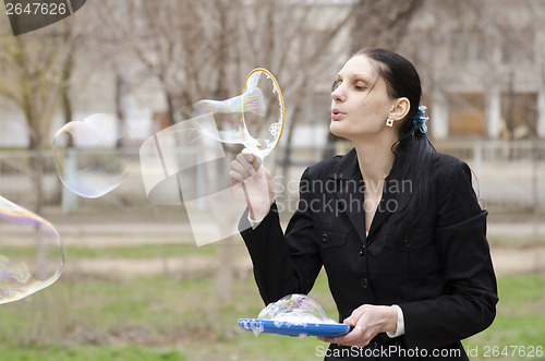 Image of girl inflates a big bubble, the bubble bursts