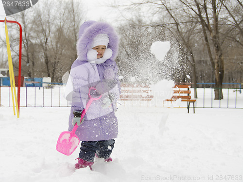 Image of Four year old girl threw herself with snow shovels