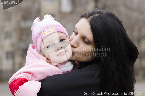 Image of little girl thoughtfully lies on shoulder of my mother