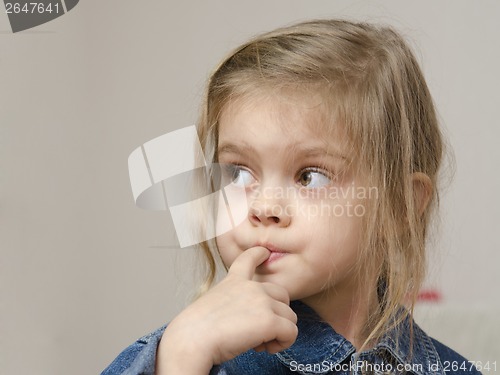 Image of Four-year-old girl with finger in mouth look left