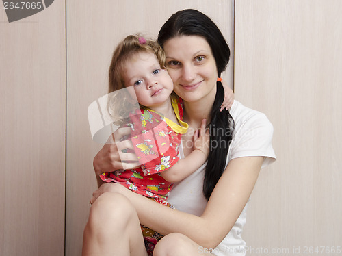 Image of happy mother, daughter at home cuddling and watching frame