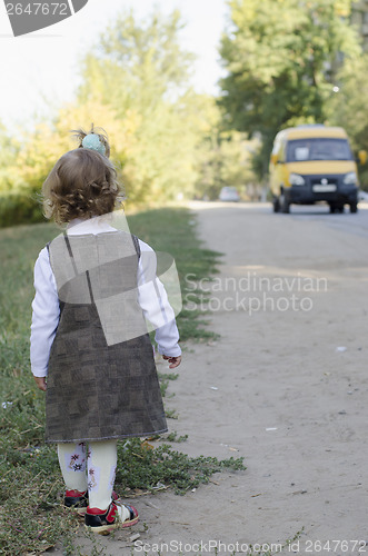 Image of little girl waits for the bus