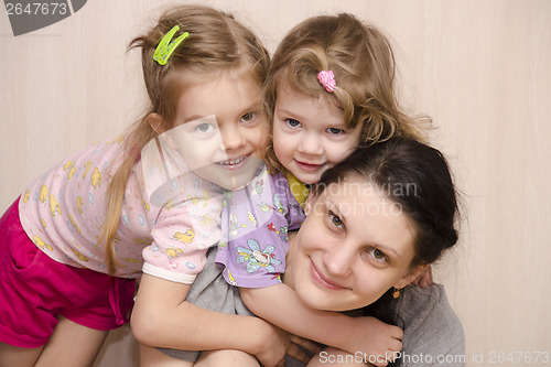 Image of Merry and happy children a mother embracing look in frame