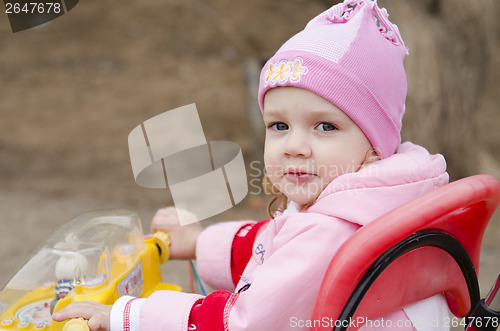 Image of little girl looks in frame sitting on bike