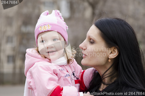 Image of little girl thoughtfully lies on shoulder of my mother