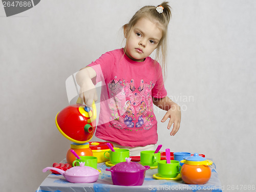 Image of Girl plays child kitchen utensils