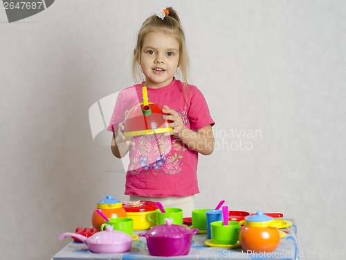 Image of Girl plays child kitchen utensils